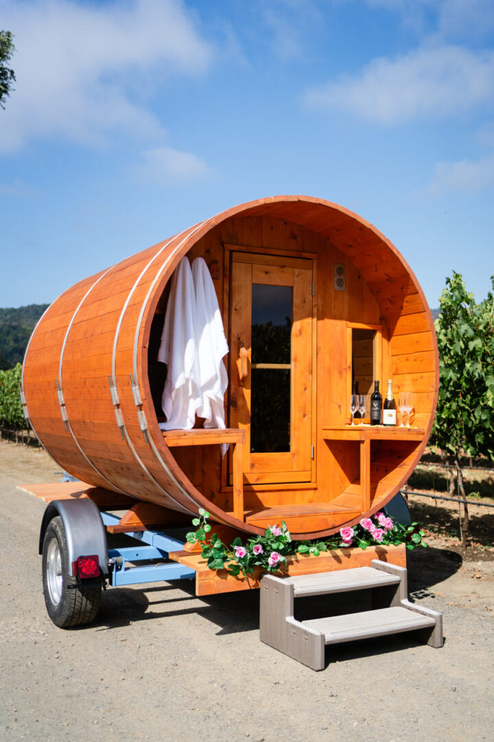 A barrel shaped trailer with a door open.