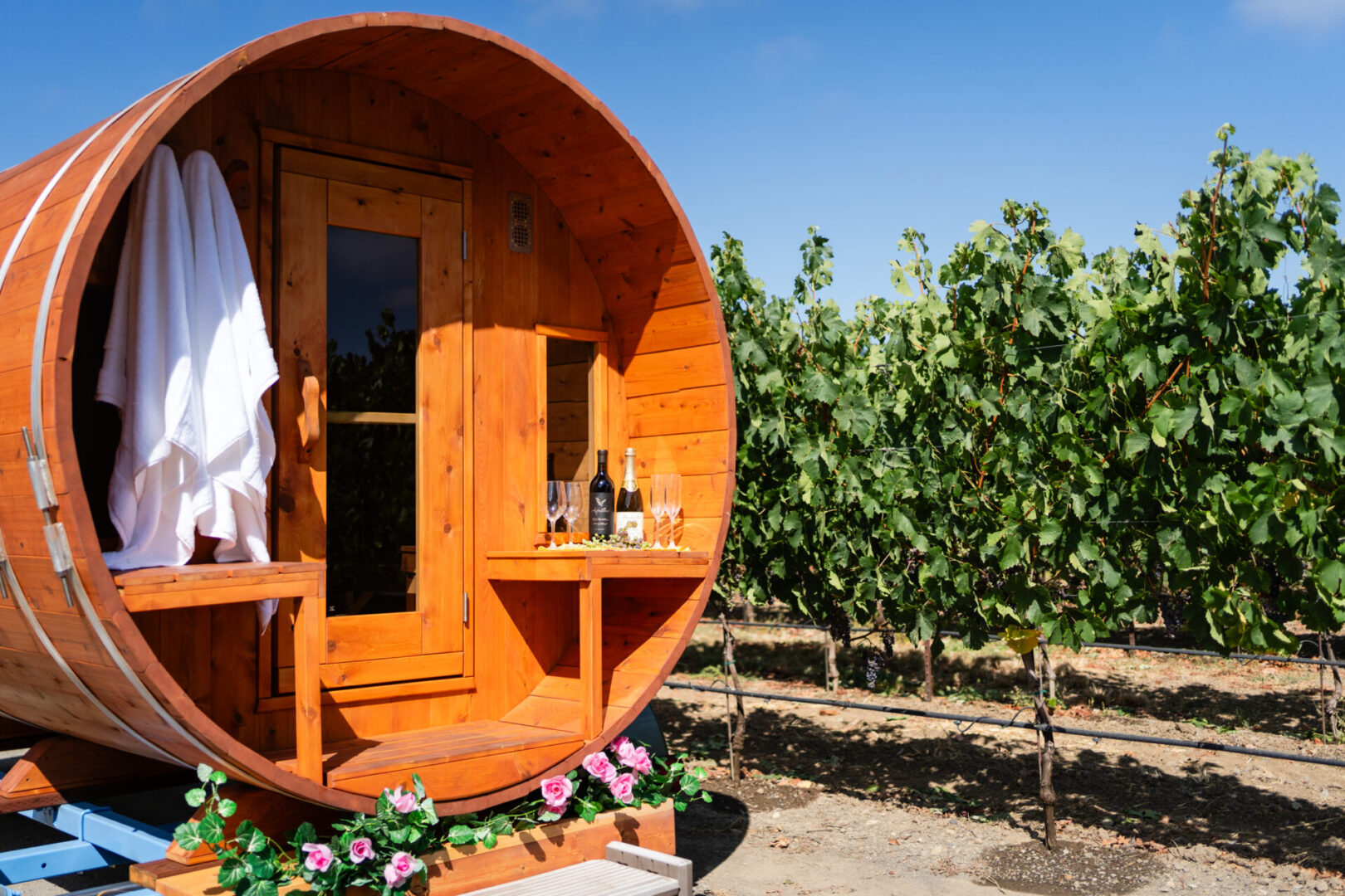 A barrel shaped house with wine bottles on the side.