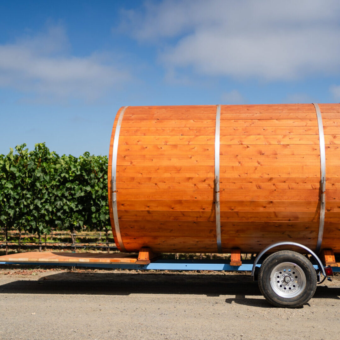 A large wooden barrel on the back of a trailer.