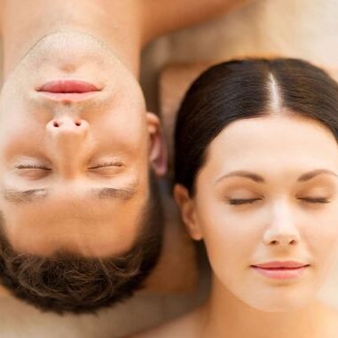 A man and woman laying on the ground.